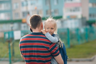 Rear view of father and daughter outdoors