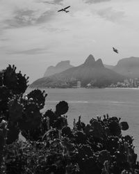 Scenic view of sea and mountains against sky