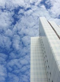 Low angle view of modern building against cloudy sky