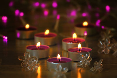 Close-up of lit tea light candles on table