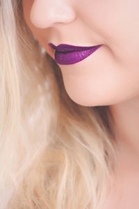 Cropped image of woman with purple lipstick