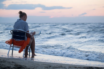 Person standing on beach at sunset