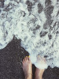 Low section of person standing on beach