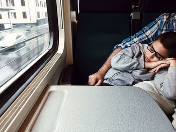 Close-up of boy sleeping on train
