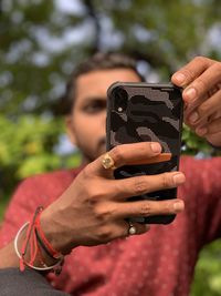 Midsection of woman photographing against blurred background