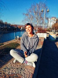 Portrait of smiling woman sitting on boat against sky