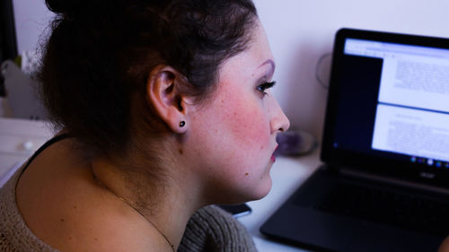 Portrait of young woman using mobile phone at home