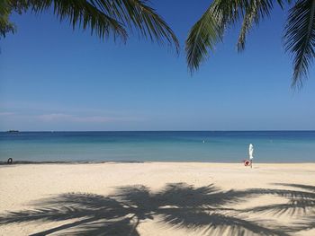 Scenic view of beach against clear blue sky