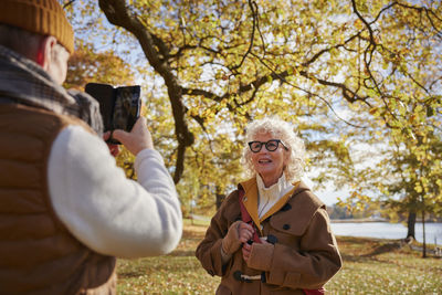 Man photographing woman with cell phone