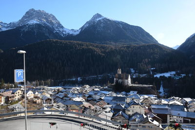 Scenic view of town by mountains against sky