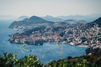 Scenic view of sea by cityscape against clear sky