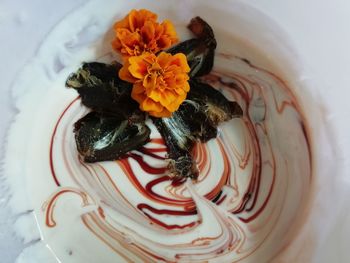 High angle view of orange flowers in plate on table