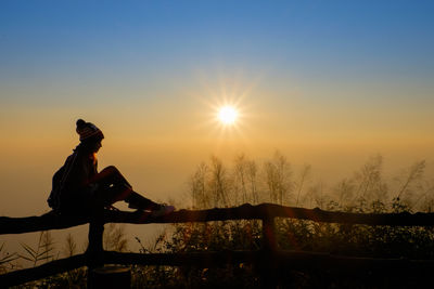 Silhouette person against orange sky during sunset