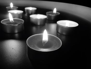 Close-up of lit tea light candles on table