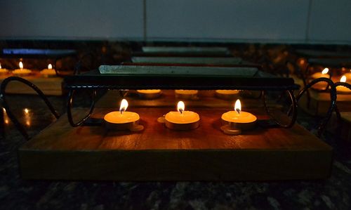 Close-up of illuminated candles on table