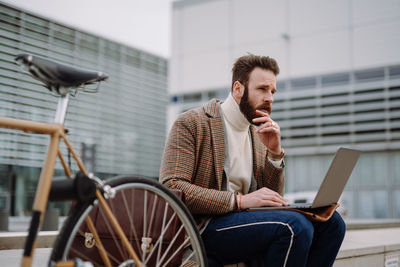 Young man using mobile phone while sitting on chair