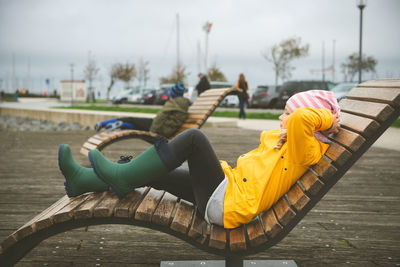 Side view of girl relaxing on chair outdoors