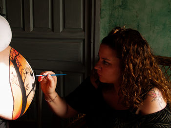 Friend painting stomach of pregnant woman at home