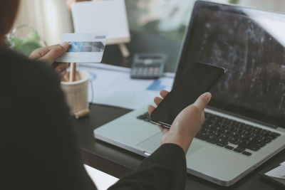 Midsection of man using laptop on table