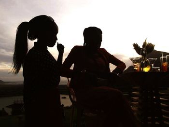 Silhouette of friends looking at sunset