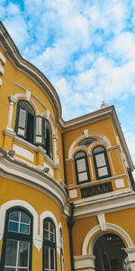 Low angle view of yellow building against sky