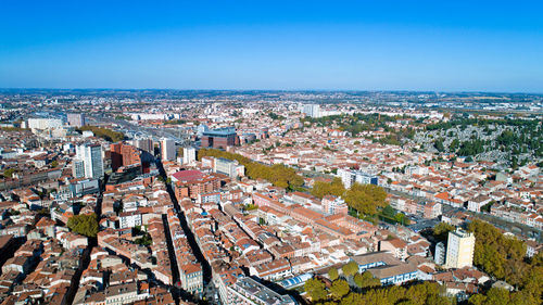 High angle view of cityscape against blue sky