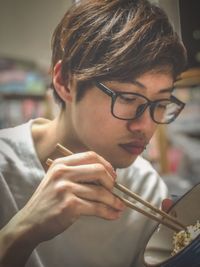 Close-up of young man eating food from bowl