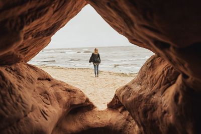 Rear view of woman standing at beach