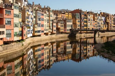 Reflection of buildings in canal against sky