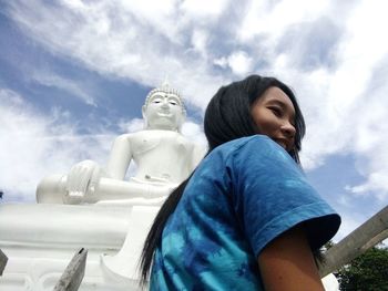 Woman against buddha statue in city