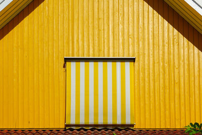 Closed wooden door of yellow building