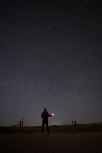 Full length of man standing on field against sky at night