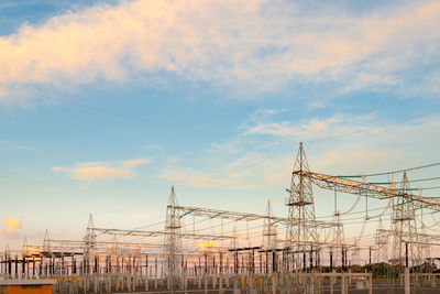 Low angle view of electricity pylon against sky during sunset