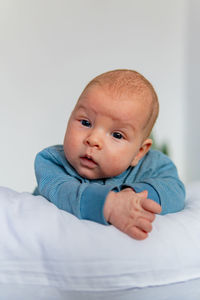 Portrait of cute baby boy chilling on bed at home