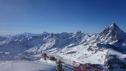 Scenic view of snowcapped mountains against clear blue sky