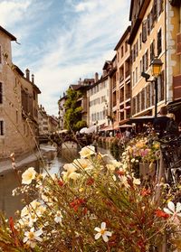 Canal amidst buildings in city against sky