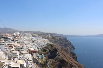 High angle view of town by sea against clear sky