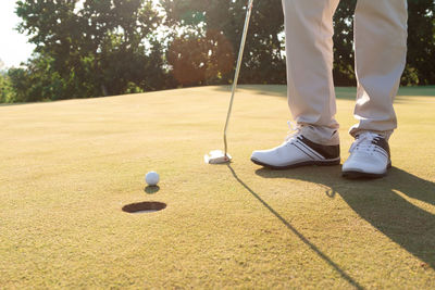 Low section of person standing on golf ball