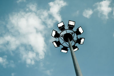 Low angle view of illuminated floodlights against sky