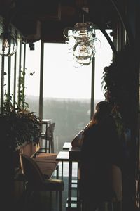 Rear view of woman sitting in restaurant