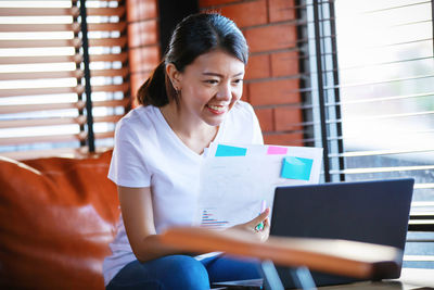 Smiling young woman using mobile phone