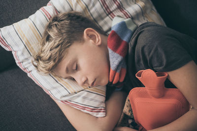 Directly above shot of ill boy sleeping on sofa at home