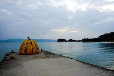 Rear view of cross on lake against sky