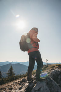 Full length of man standing on rock against sky