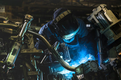 Worker welding at factory