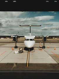 Airplane on airport runway against sky