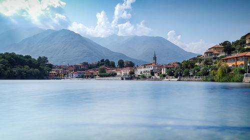 Scenic view of lake by buildings against sky