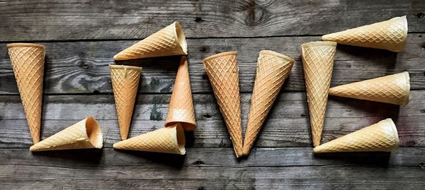 High angle view of love text made with ice cream cones on wooden table