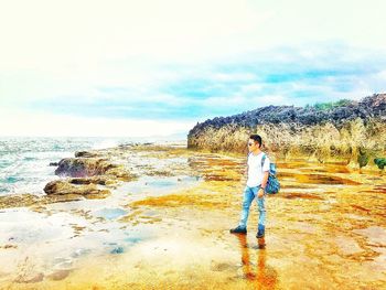 Full length of man standing in water against sky