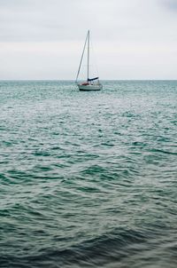 Sailboat sailing on sea against sky